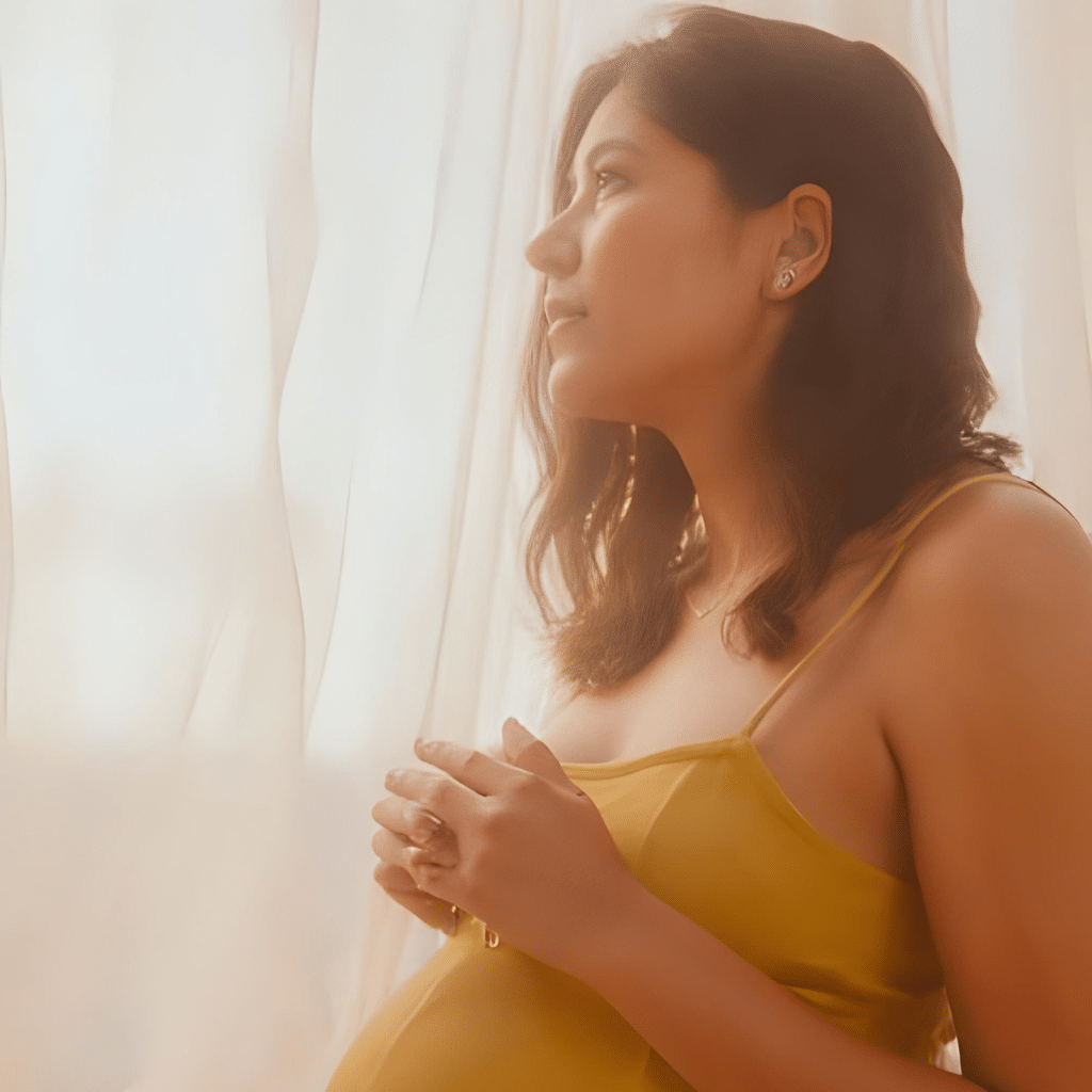 Pregnant woman applying mineral sunblock to prevent melasma and sun damage, emphasizing the need for the best sunscreen for pregnancy.
